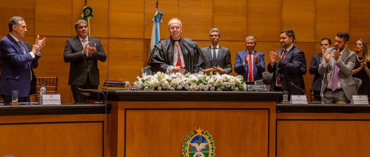 Presidente do TJRJ, des. Ricardo Rodrigues Cardozo, em pé aplaudido por autoridades na mesa de honra do Tribunal Pleno