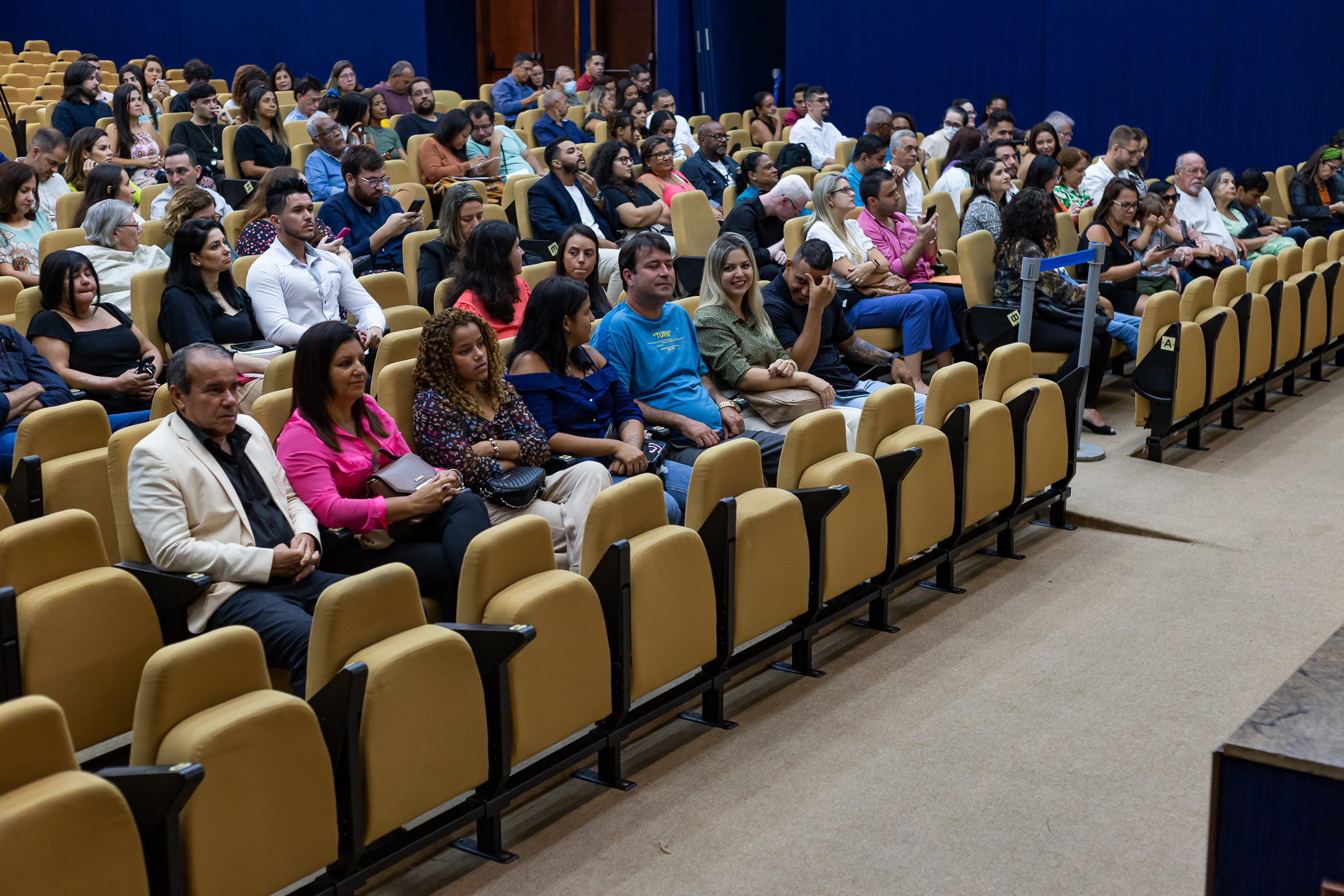 Imagem no Auditório Antônio Carlos Amorim. Sentados novos servidores e familiares acompanhando a cerimônia de posse 